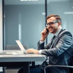 Professioneller Headhunter Heidelberg am Schreibtisch bei einem Telefonat, umgeben von Notizen und einem Laptop.
