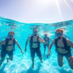 Tauchschule Playa del Carmen: Lebendige Taucher erkunden eine farbenfrohe Unterwasserwelt.